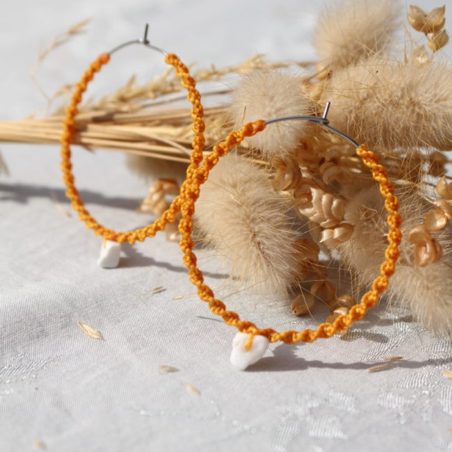 Ces créoles allient à la fois un style bohème et moderne. Le macramé apporte une touche artisanale et naturelle, tandis que la forme circulaire et la pierre en semi-précieuse