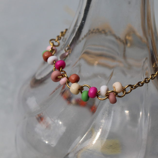 Bracelet en perles colorées montées sur une chaine dorée. Pour une touche de couleur sur votre tenue. Matériaux : Acier inoxydable doré et perles.