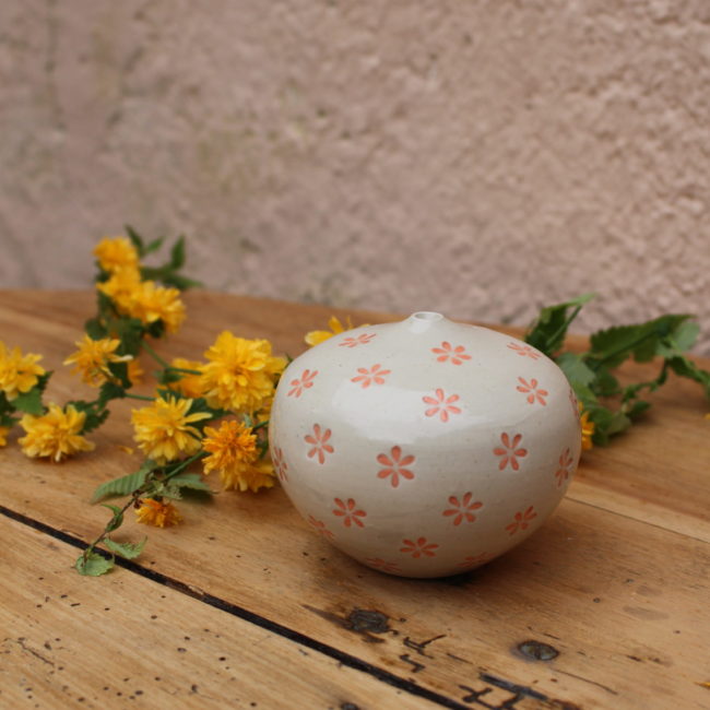 Adorable mini vase en céramique, forme ronde, couleur crème, décoré de petites fleurs roses.